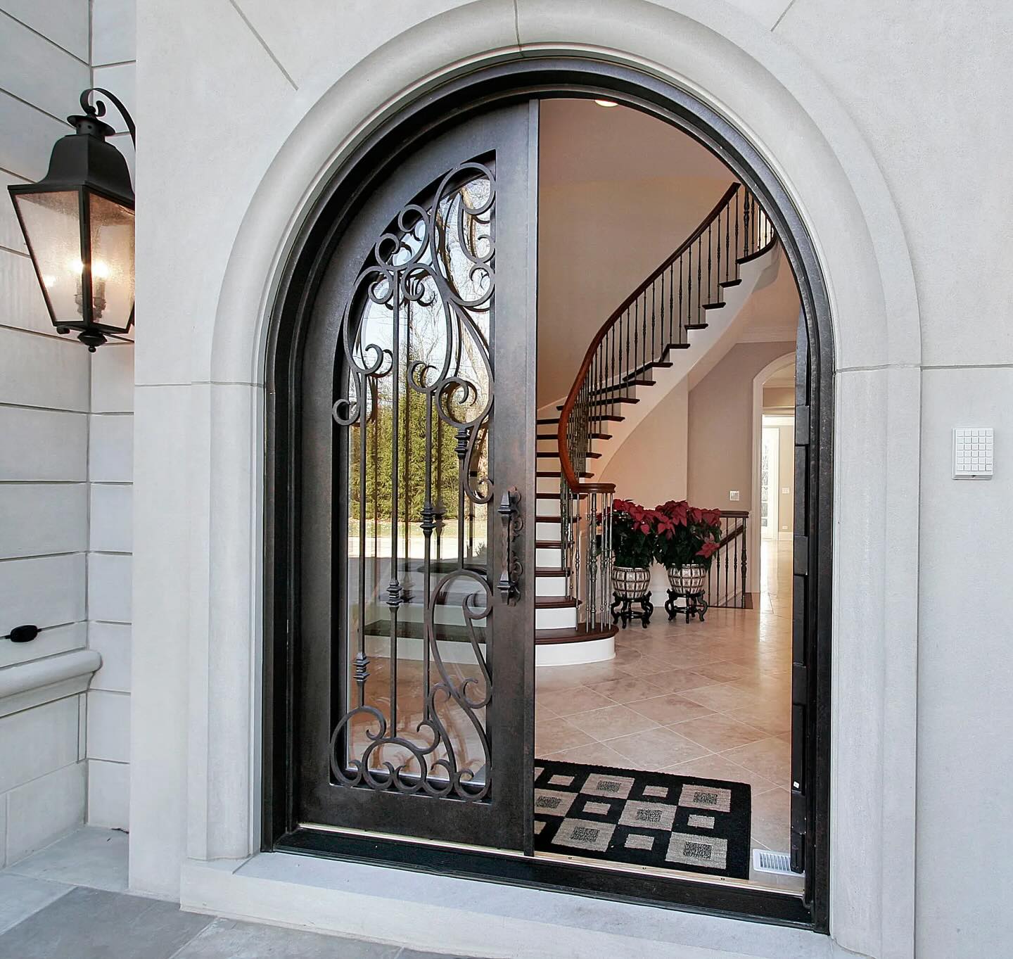 Wrought iron arched double door and grand entryway by Artistic Entrances
