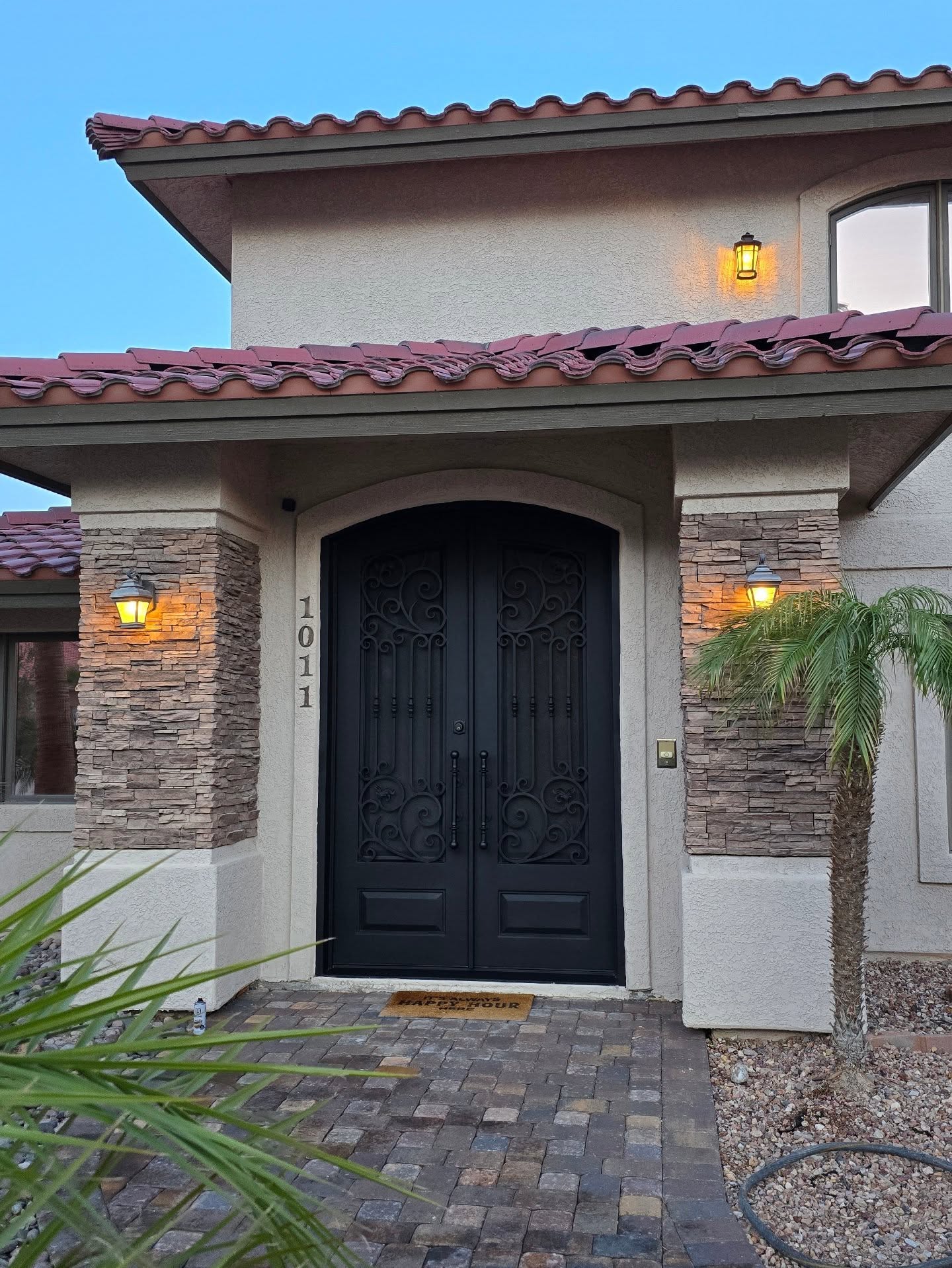 Grand wrought iron arched double door with scrollwork