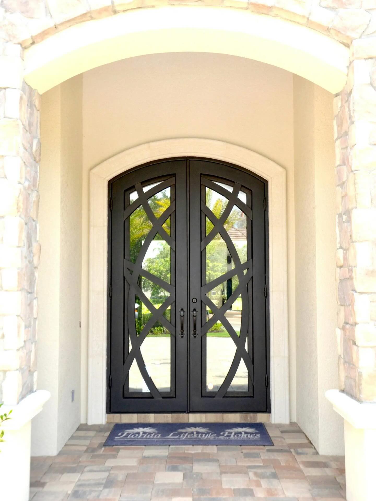Custom wrought iron double door with ornate scrollwork and glass